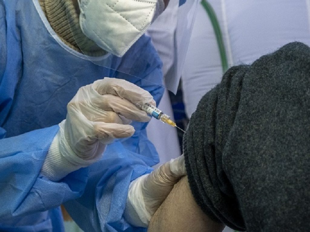 Un infermiere inietta la terza dose del vaccino contro il Covid