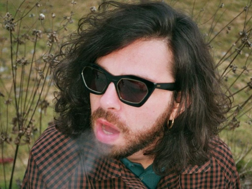 Il cantante Mobrici in primo piano fuma