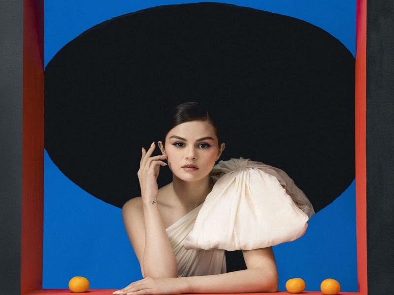 La cantante Selena Gomez in abito rosa con fiocco alla finestra per il suo nuovo album