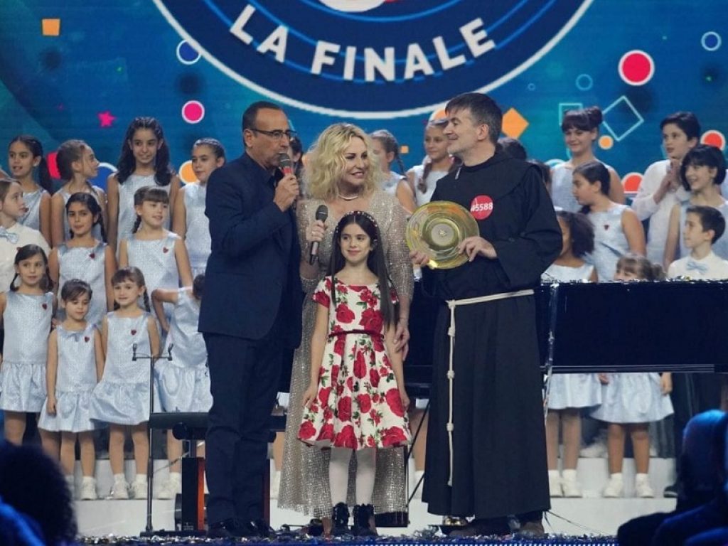 Carlo Conti premia il vincitore dello Zecchino d'Oro nella finale