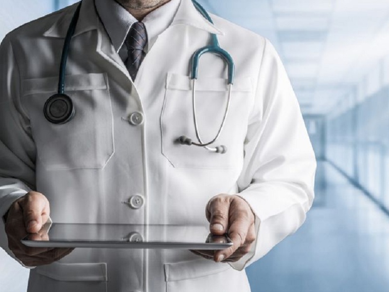 Dottore in corsia di ospedale con tablet