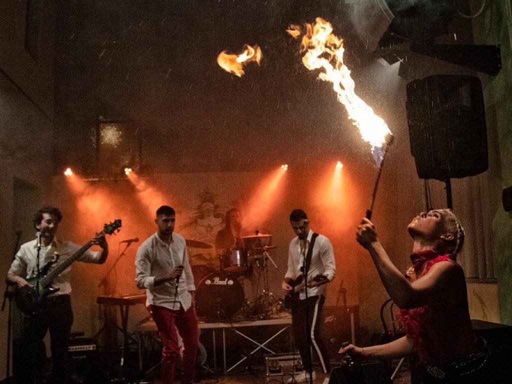 La band musicale dei Poison Blackout canta davanti a una mangiafuoco