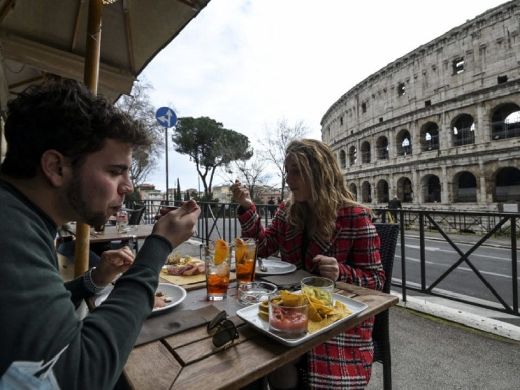Due giovani senza mascherina al ristorante a Roma di fronte al Colosseo green pass