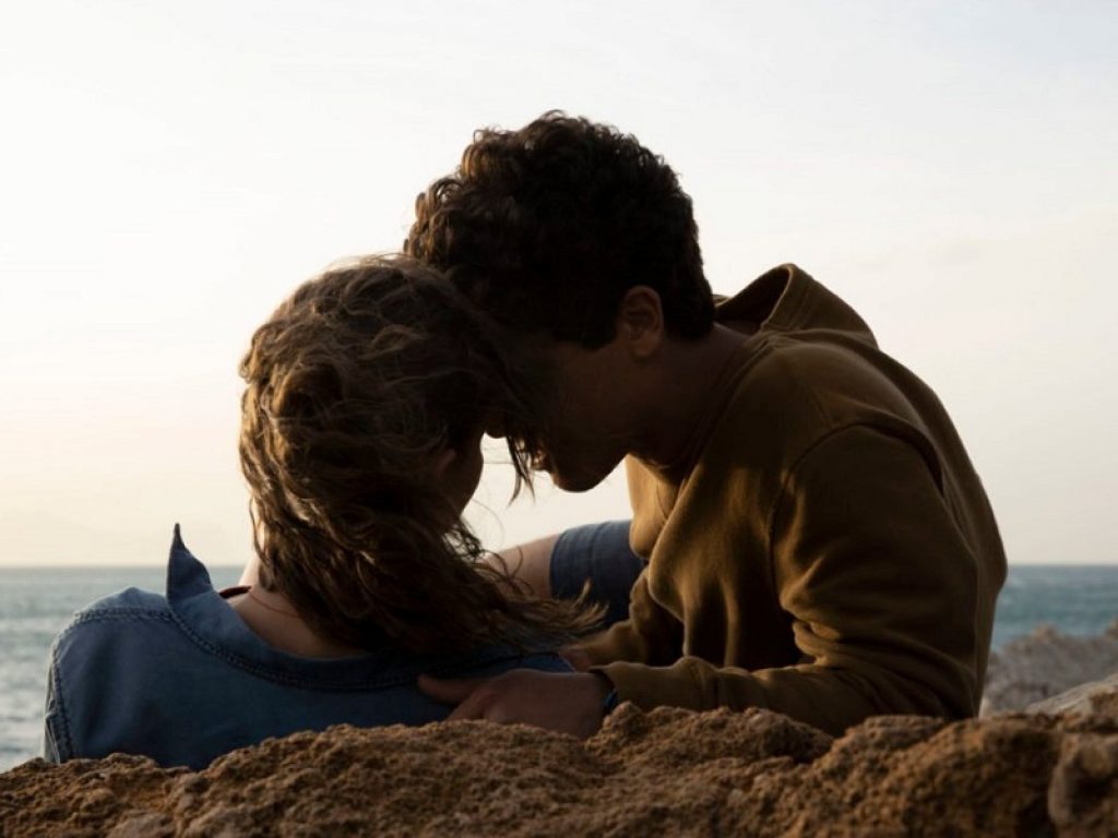 Bacio sugli scogli dei due giovani protagonisti del film Sulla stessa onda